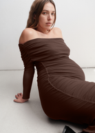 Woman wearing a brown off-shoulder dress on a white background