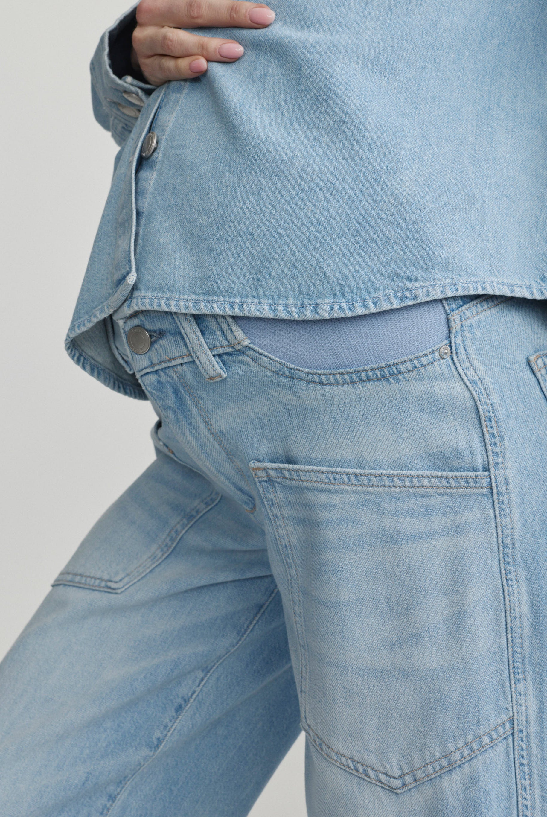 Light blue denim jacket and jeans on a plain background