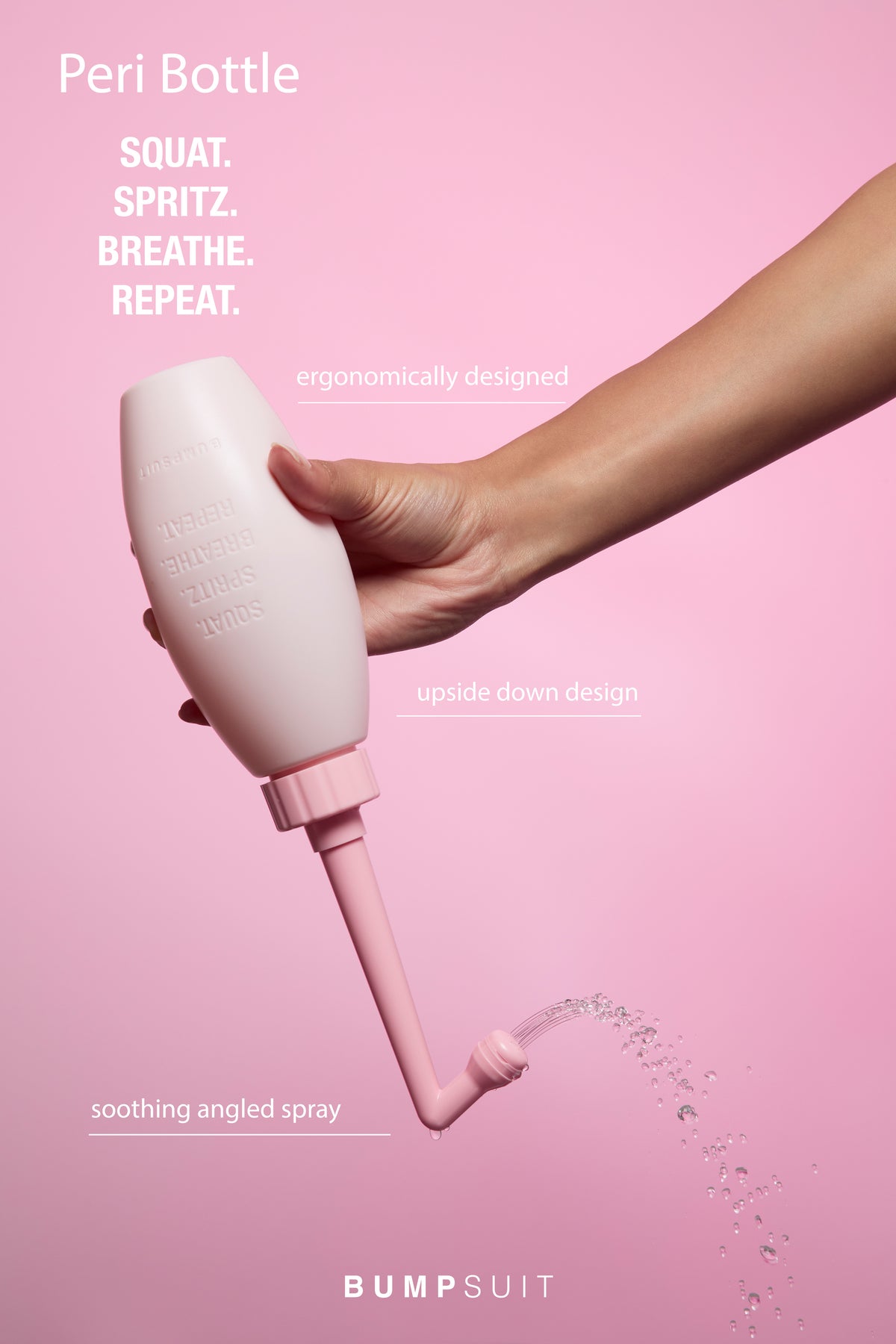 Close-up of a pink peri bottle held in a hand showcasing soothing angled spray and upside down design on a pink background