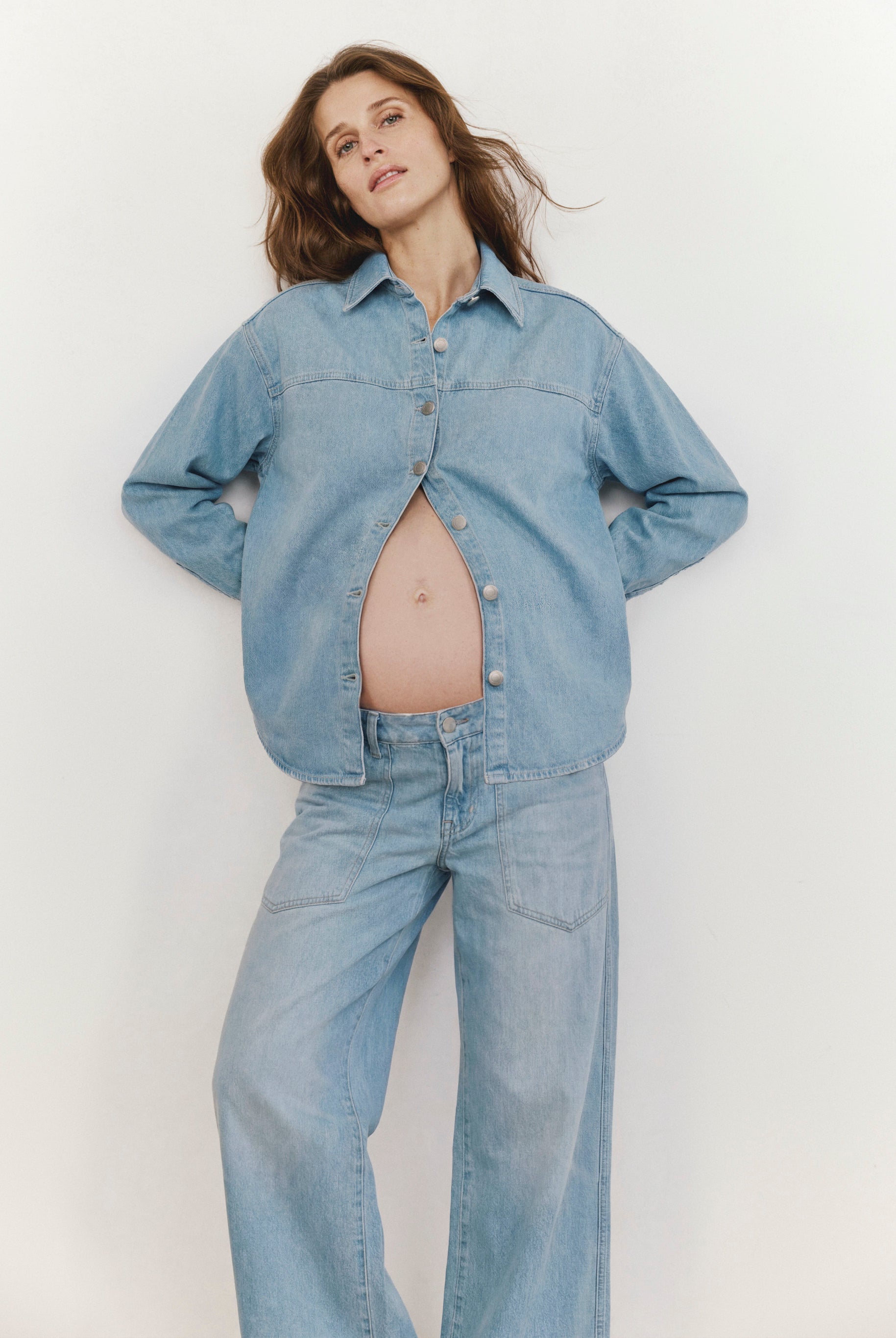 Woman wearing a denim outfit against a plain background