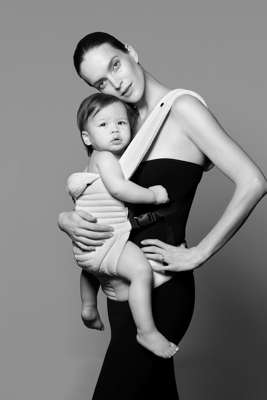 Model with a baby in the bumpsuit baby carrier shot in black and white