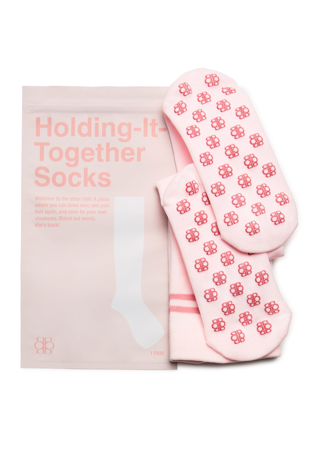 Close-up of ICE PINK compression socks showcasing a repeating red logo pattern beside pink packaging on a white background
