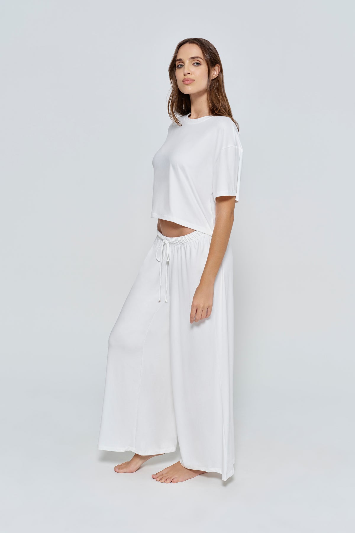 Woman wearing the Bumpsuit Maternity Cloud Short Sleeve Crop Tee in Ivory
