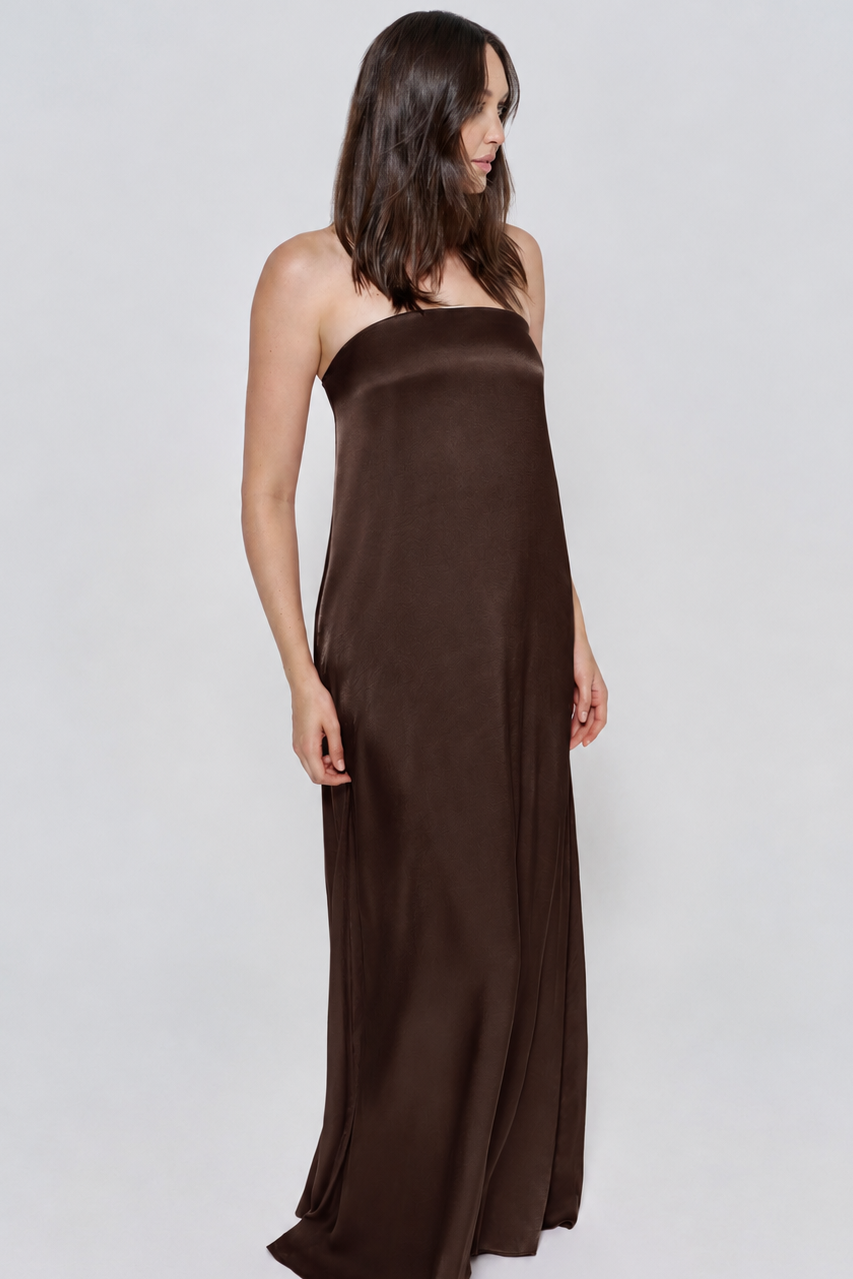 Pregnant woman wearing a Bumpsuit brushed satin strapless gown in a chocolate color against a white background