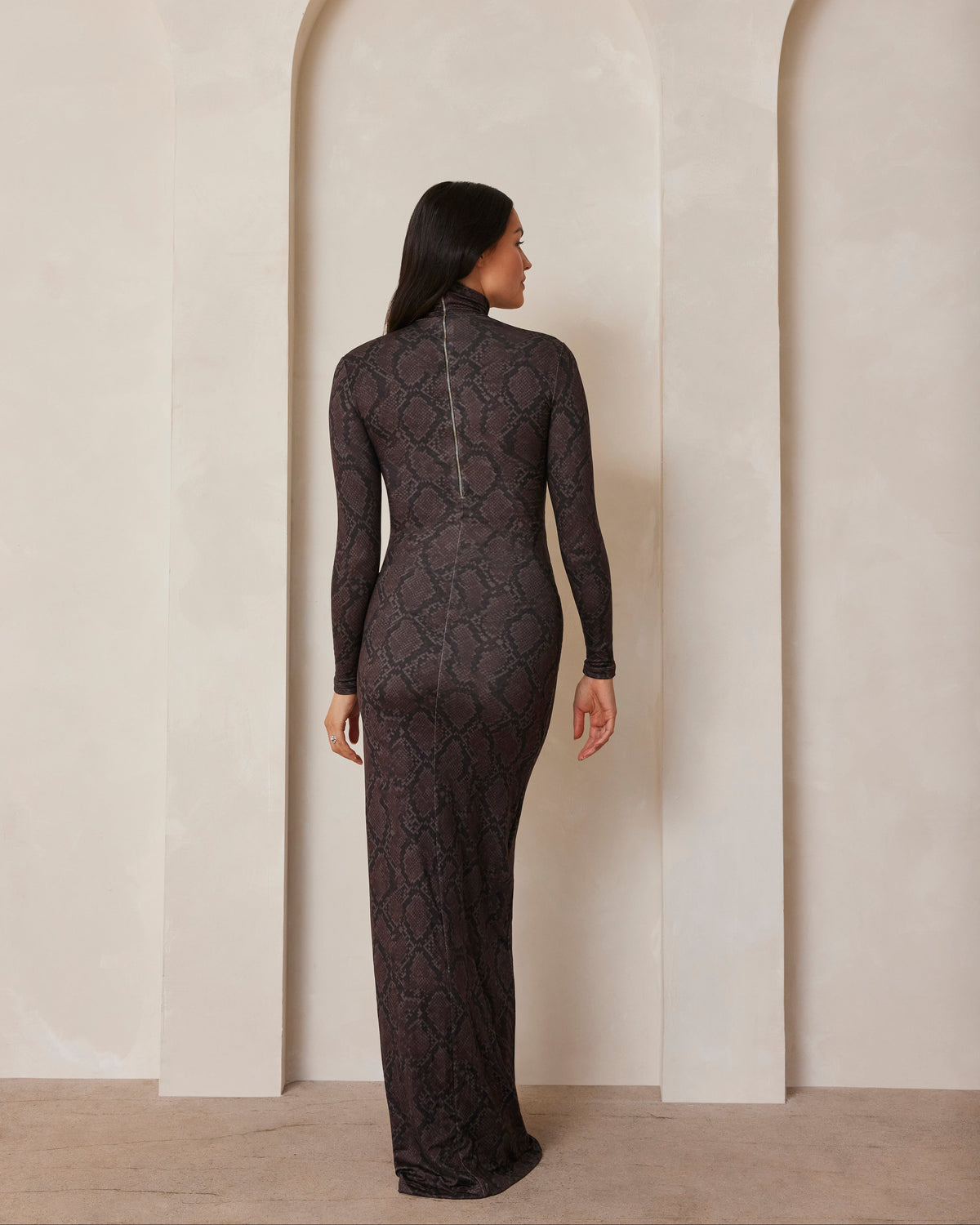 Pregnant model wearing a turtleneck long sleeve maxi dress in a snake print