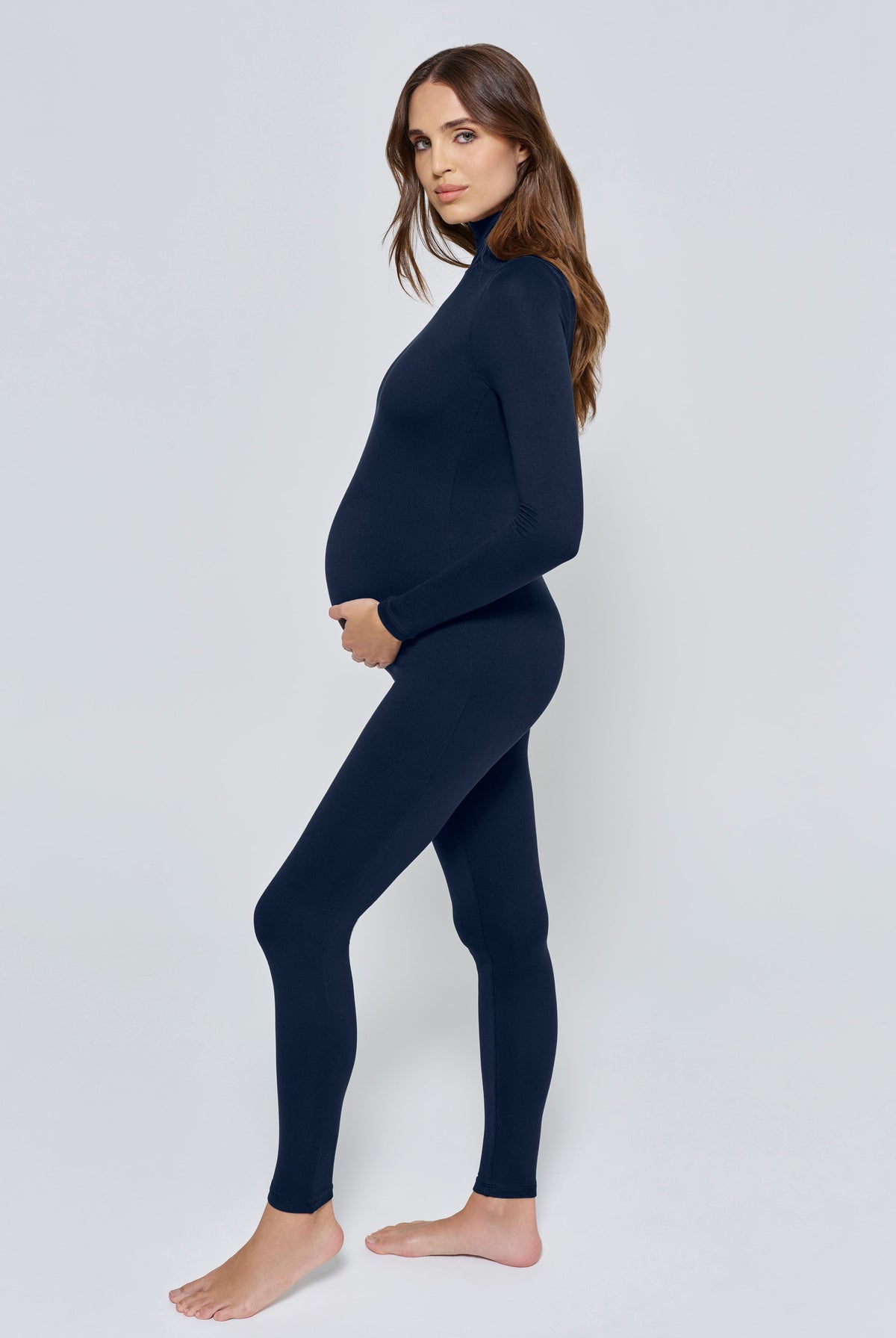 Pregnant woman wearing the Penelope Bumpsuit in Navy