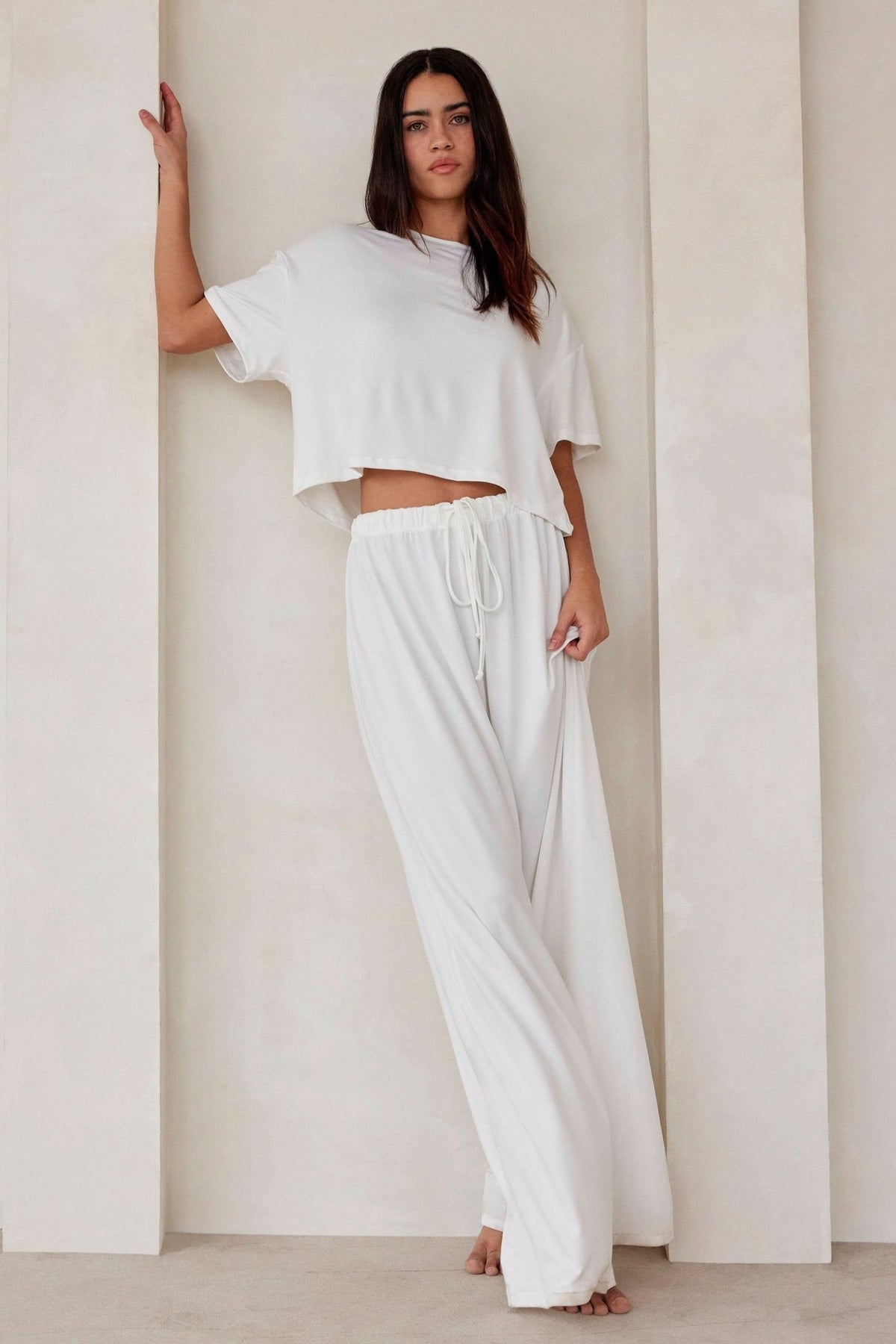 Woman wearing the Bumpsuit Maternity Cloud Short Sleeve Crop Tee in Ivory