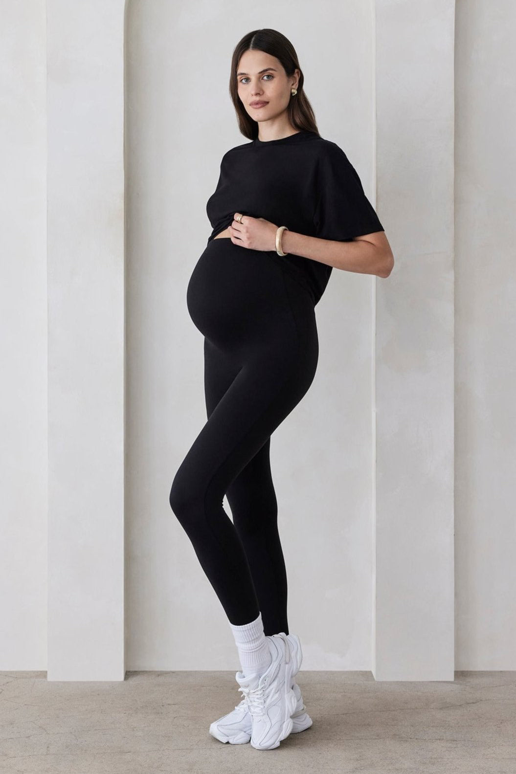 Pregnant woman wearing the Bumpsuit maternity the high waist full length legging in black
