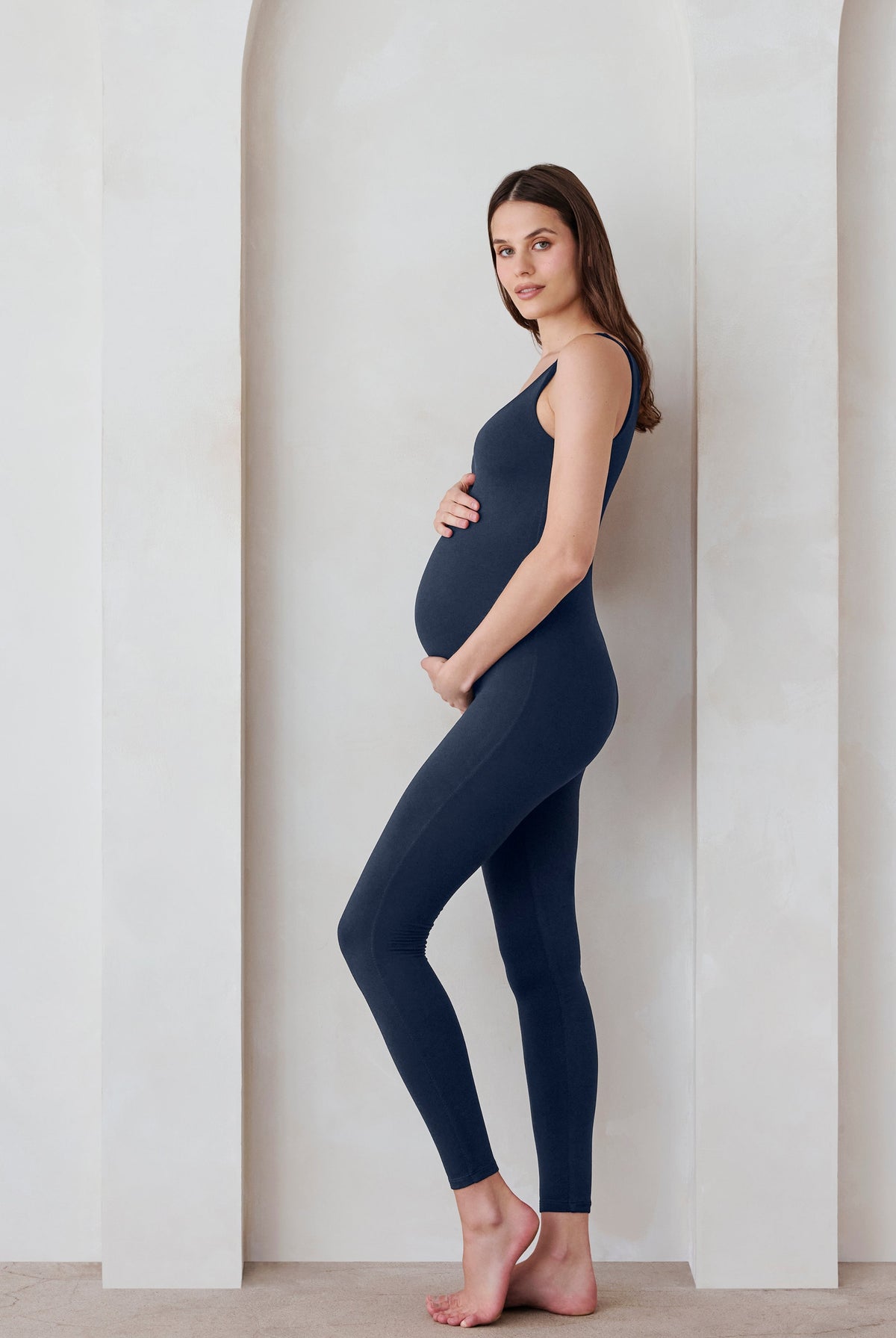 Pregnant woman in a navy jumpsuit by Bumpsuit