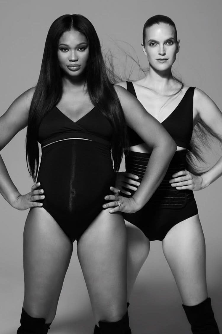 Front view of The Reversible Comfy Nursing Bra showcasing its black reversible design on two models in a gray studio