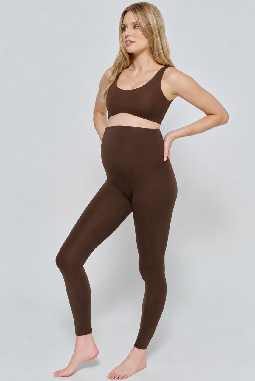 Woman wearing a chocolate brown athletic outfit on a white background