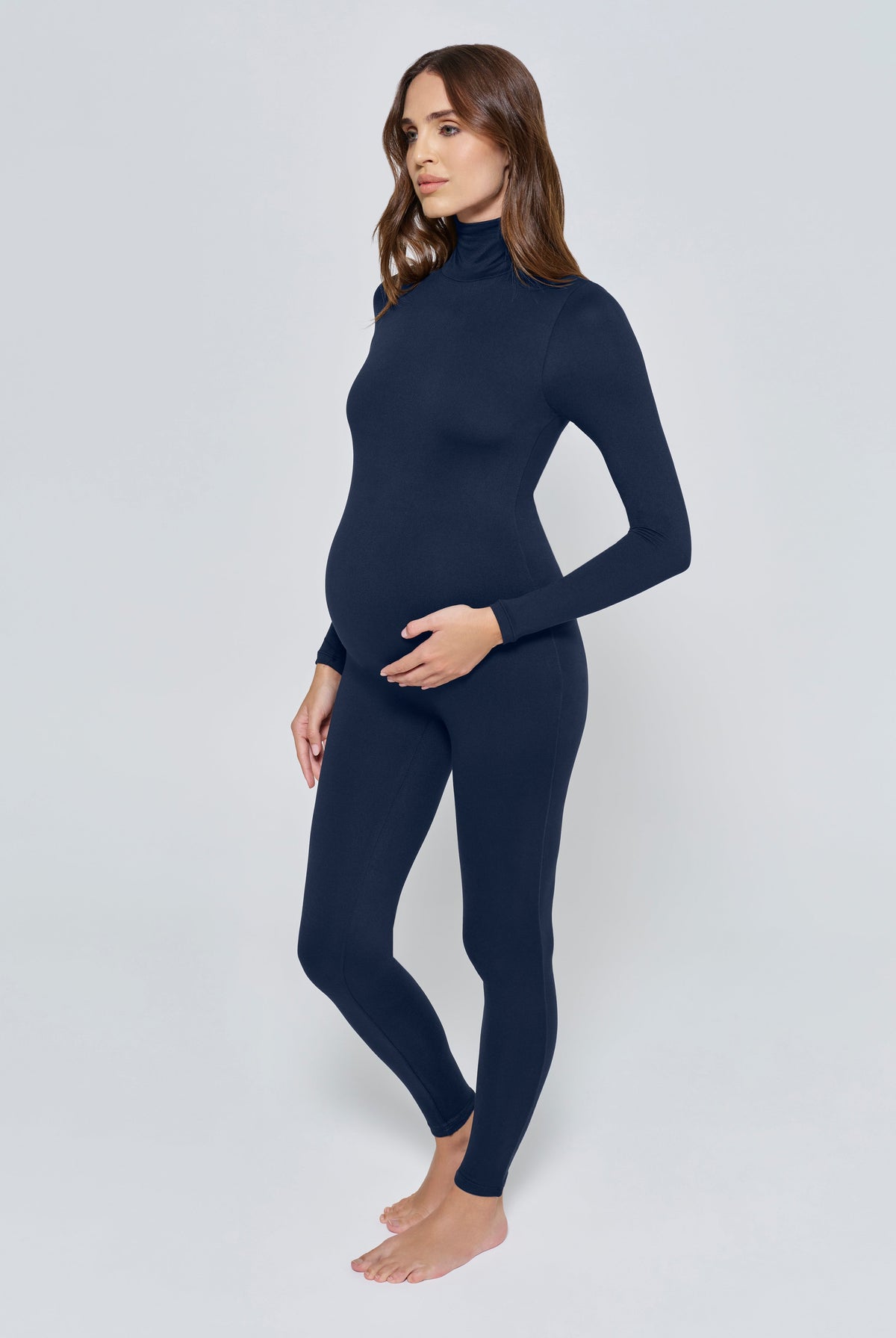 Pregnant woman wearing the Penelope Bumpsuit in Navy