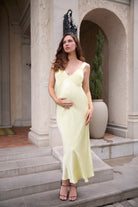 Woman in a light yellow dress standing on steps outdoors