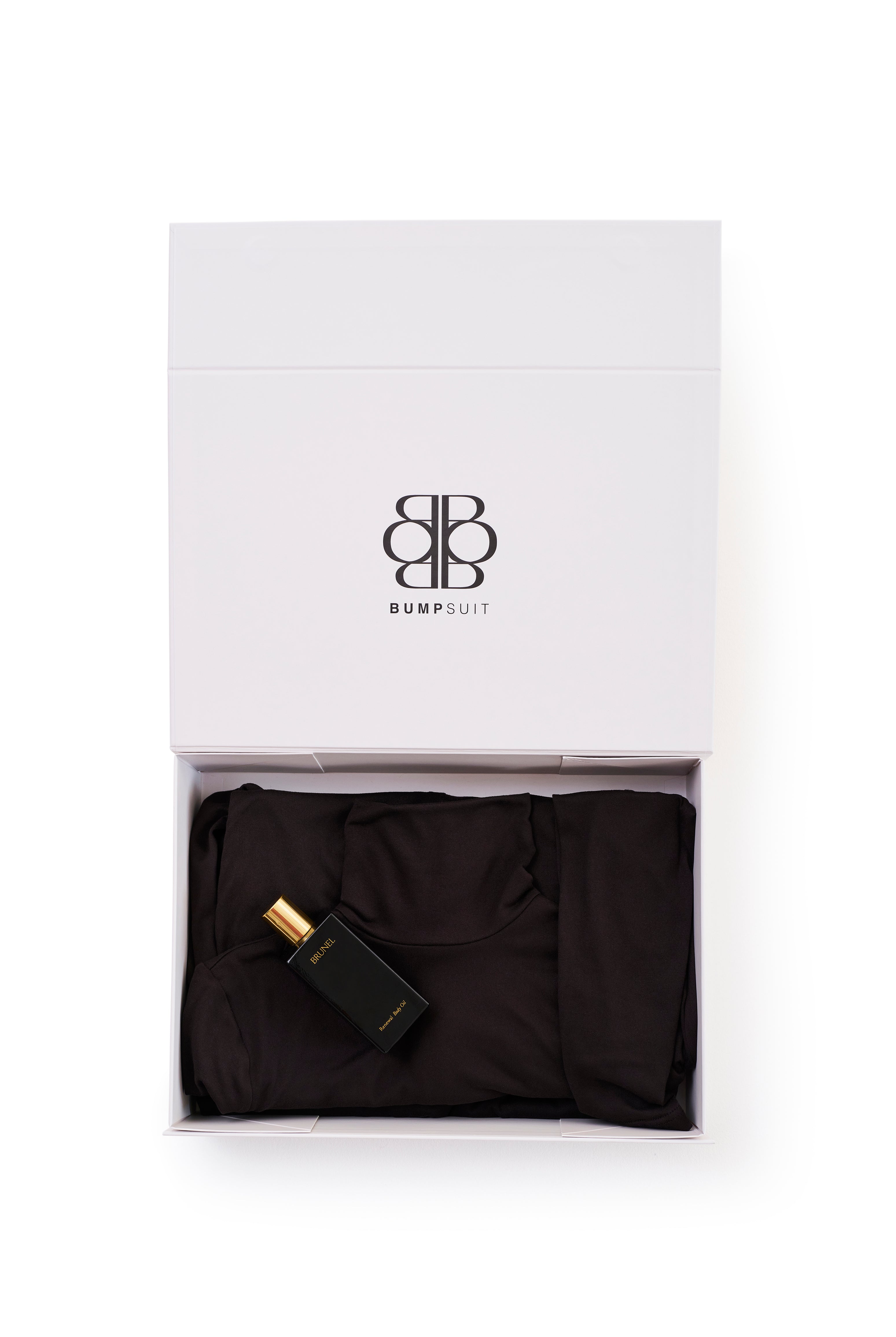white box with the bumpsuit Monica dress in black and a body oil inside