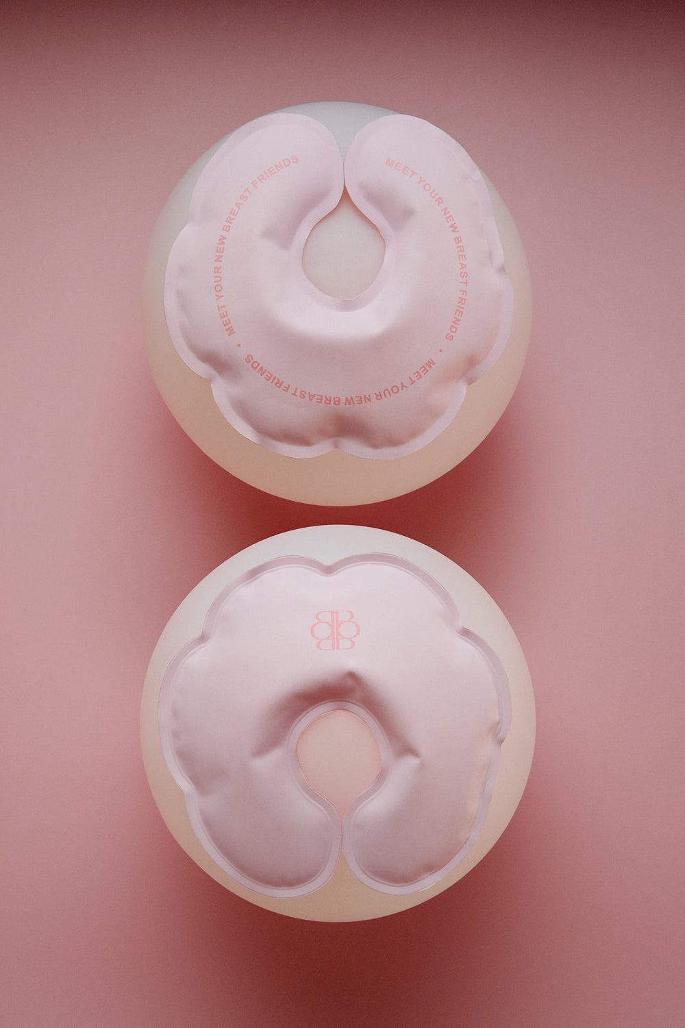 Top view of HOT N COLD BREASTIES breast therapy packs showing paired pink reusable packs on a pink background