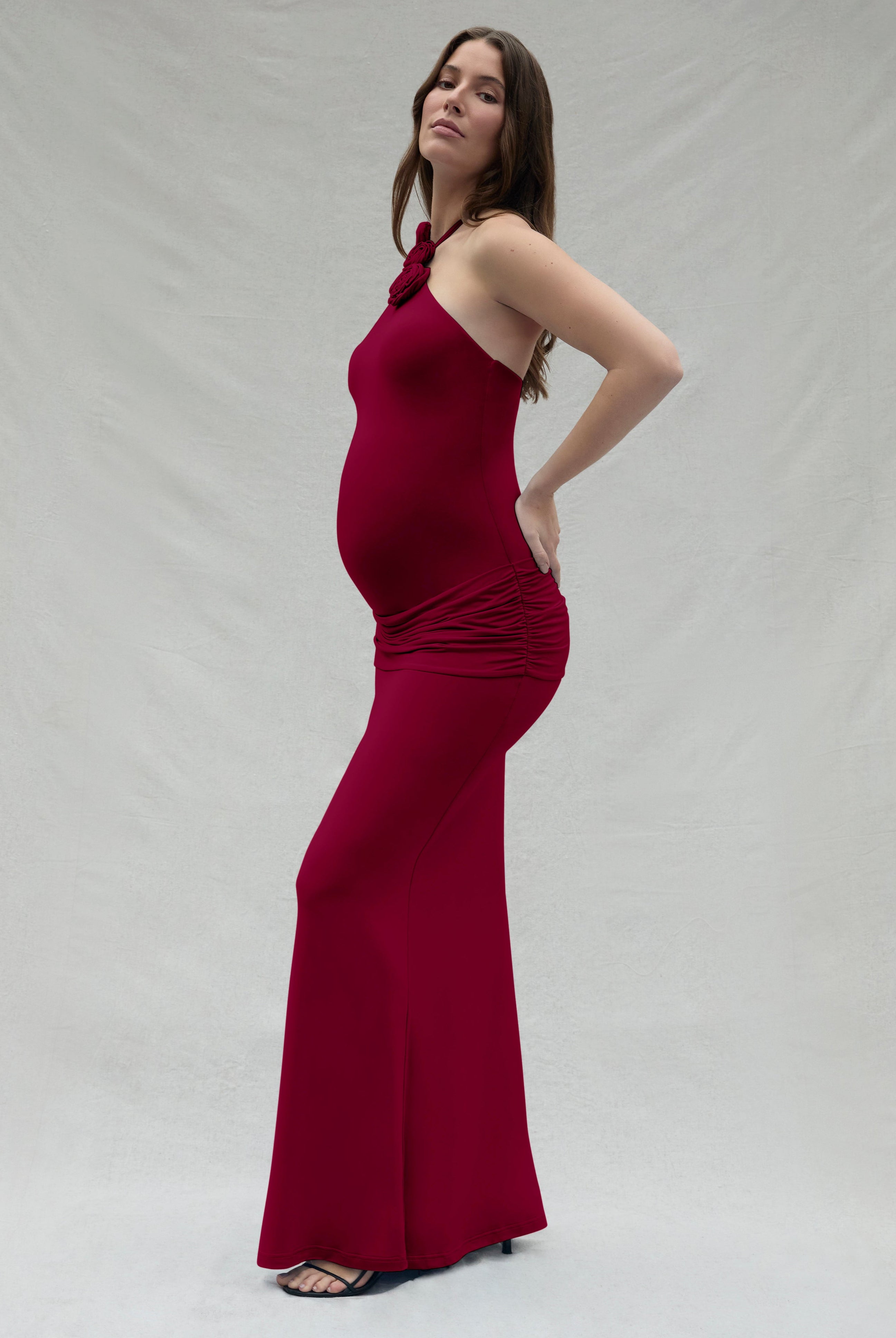 Woman wearing a burgundy dress against a plain background