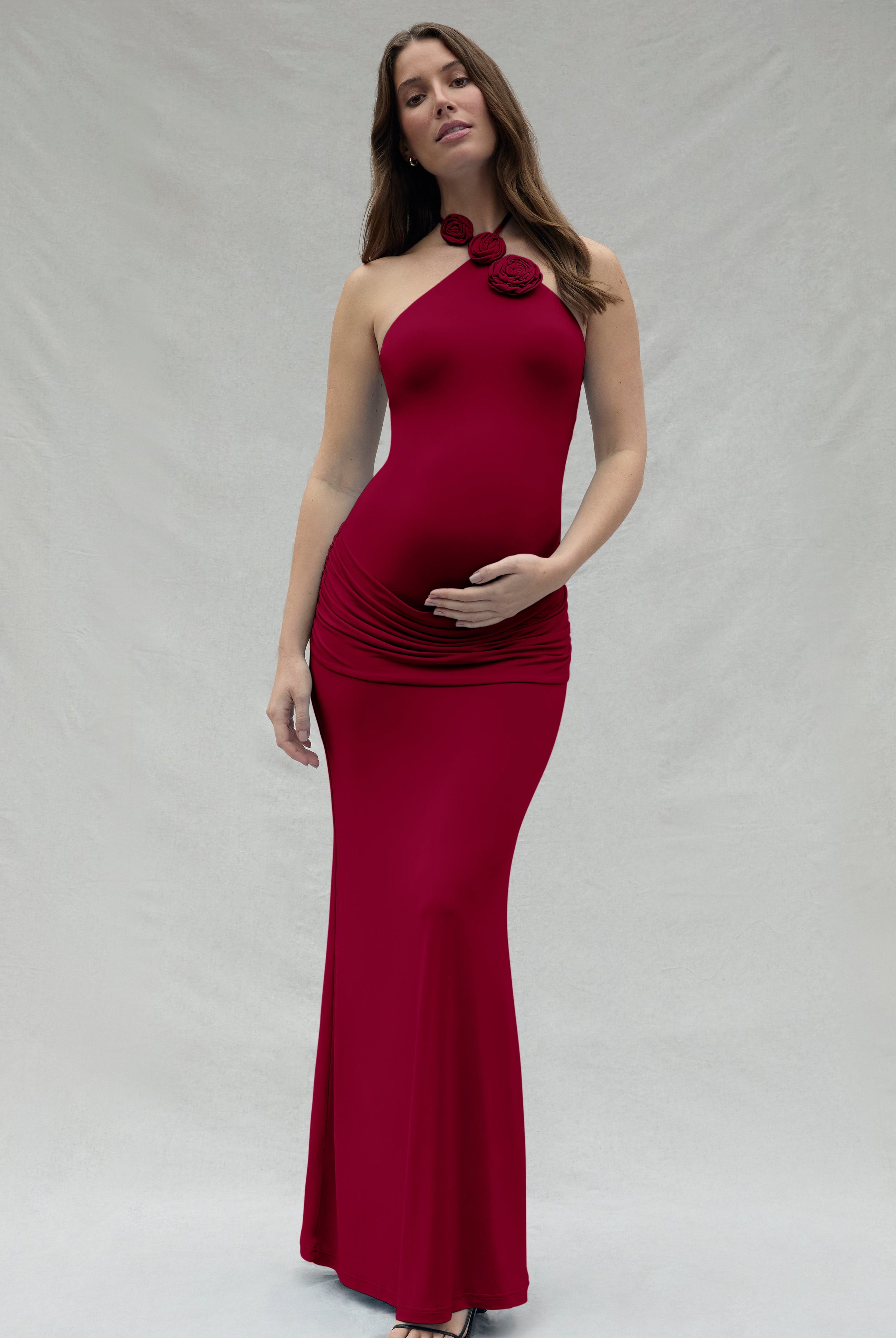 Woman wearing a burgundy dress with a floral detail on a white background