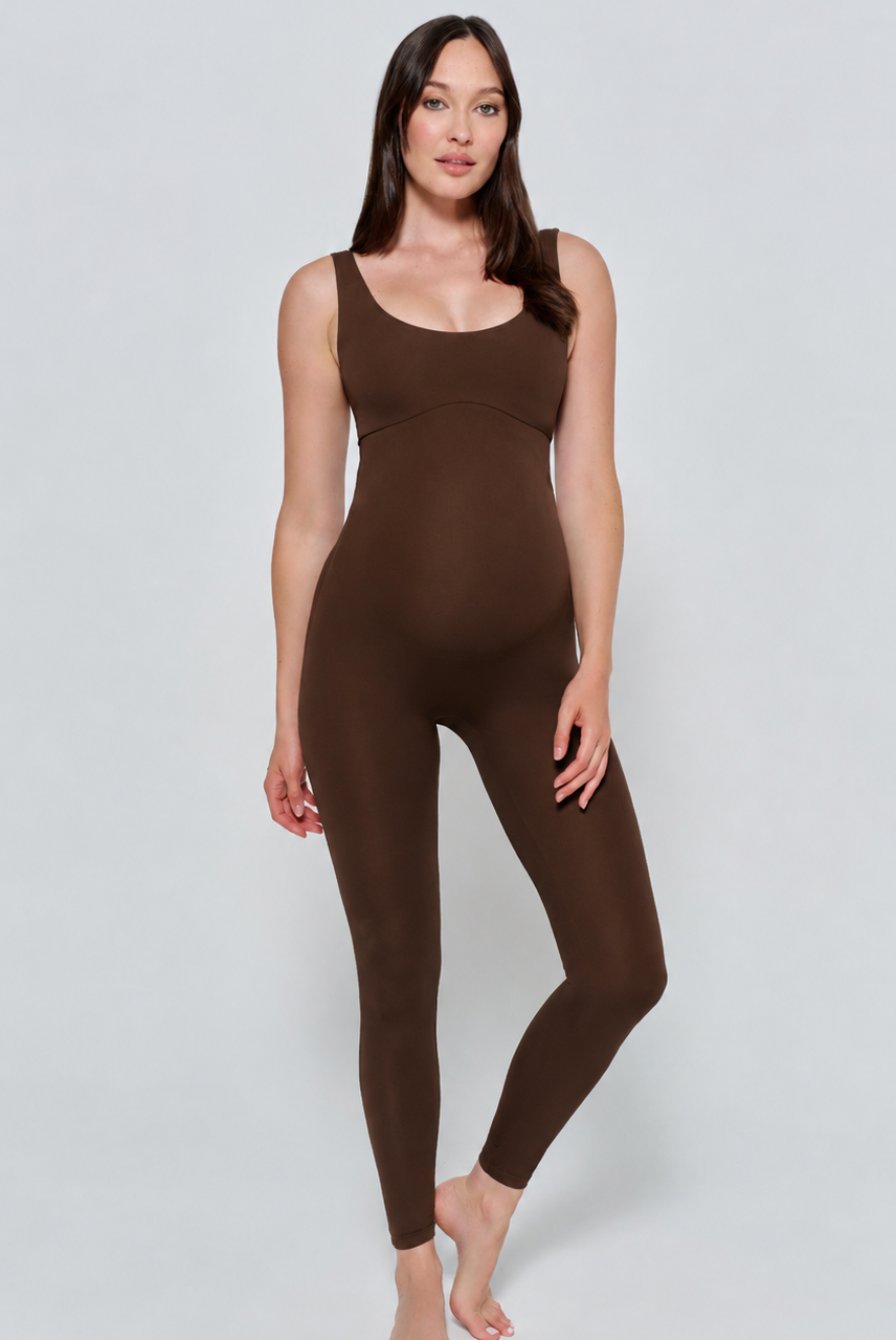 Woman wearing a chocolate brown Bumpsuit bodysuit on a light gray background