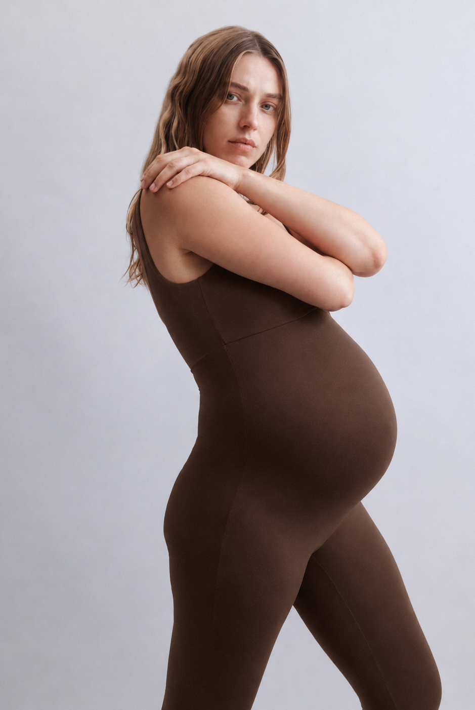 Woman wearing a Bumpsuit Chocolate brown bodysuit against a plain background