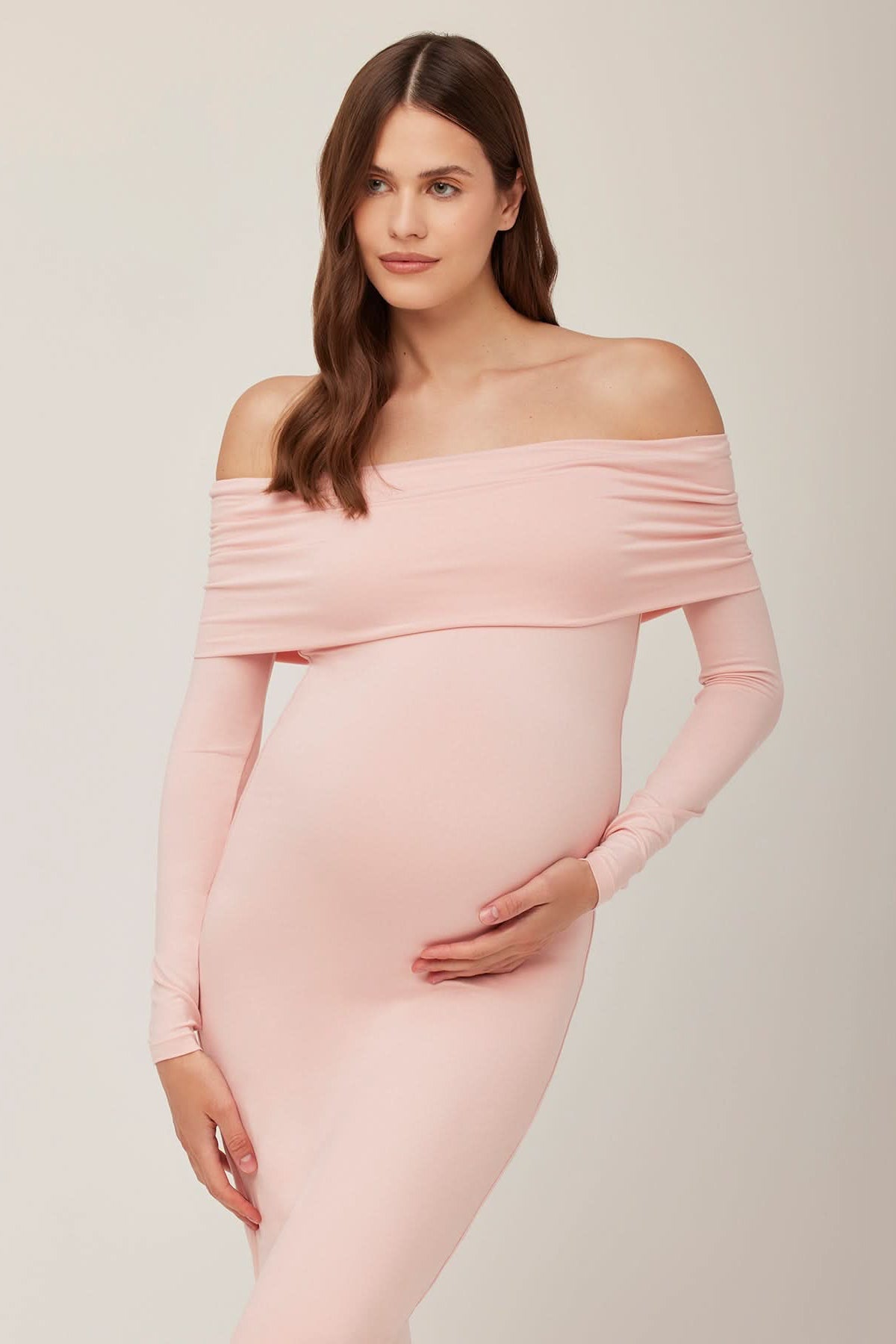 Pregnant woman wearing a dusty pink off-shoulder dress