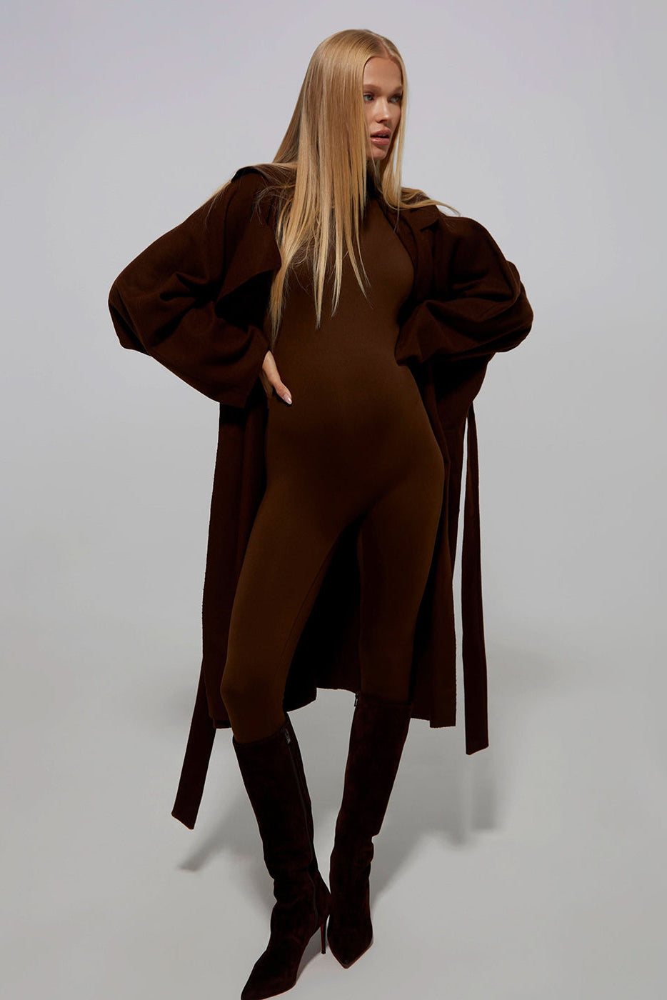Model Vita Sidorkina wears the penelope maternity turtleneck longsleeve jumpsuit by Bumpsuit in chocolate