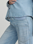 Light blue denim jacket and jeans on a plain background