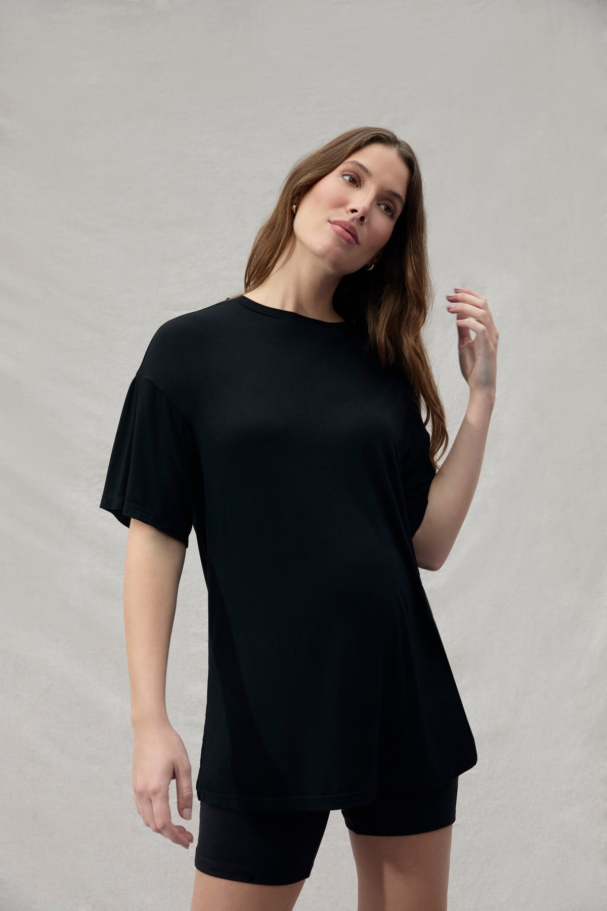 Woman wearing a shirt dress against a plain background
