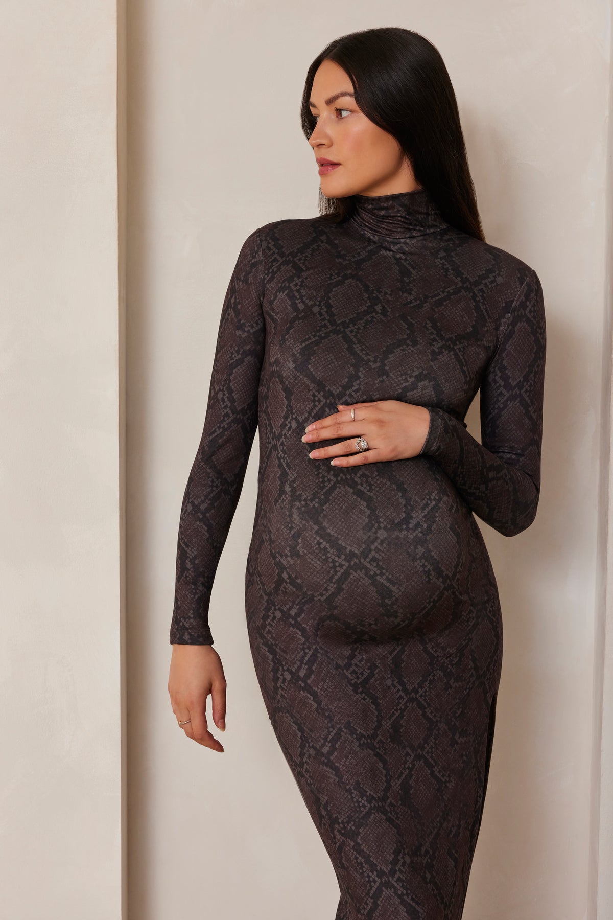 Pregnant model wearing a turtleneck long sleeve maxi dress in a snake print