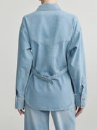 Light blue denim jacket worn by a person on a plain background