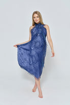 Pregnant woman wearing a spell and jumpsuit blue patterned scarf as dress on a white background