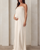 Pregnant woman wearing a Bumpsuit brushed satin gown in champagne color 