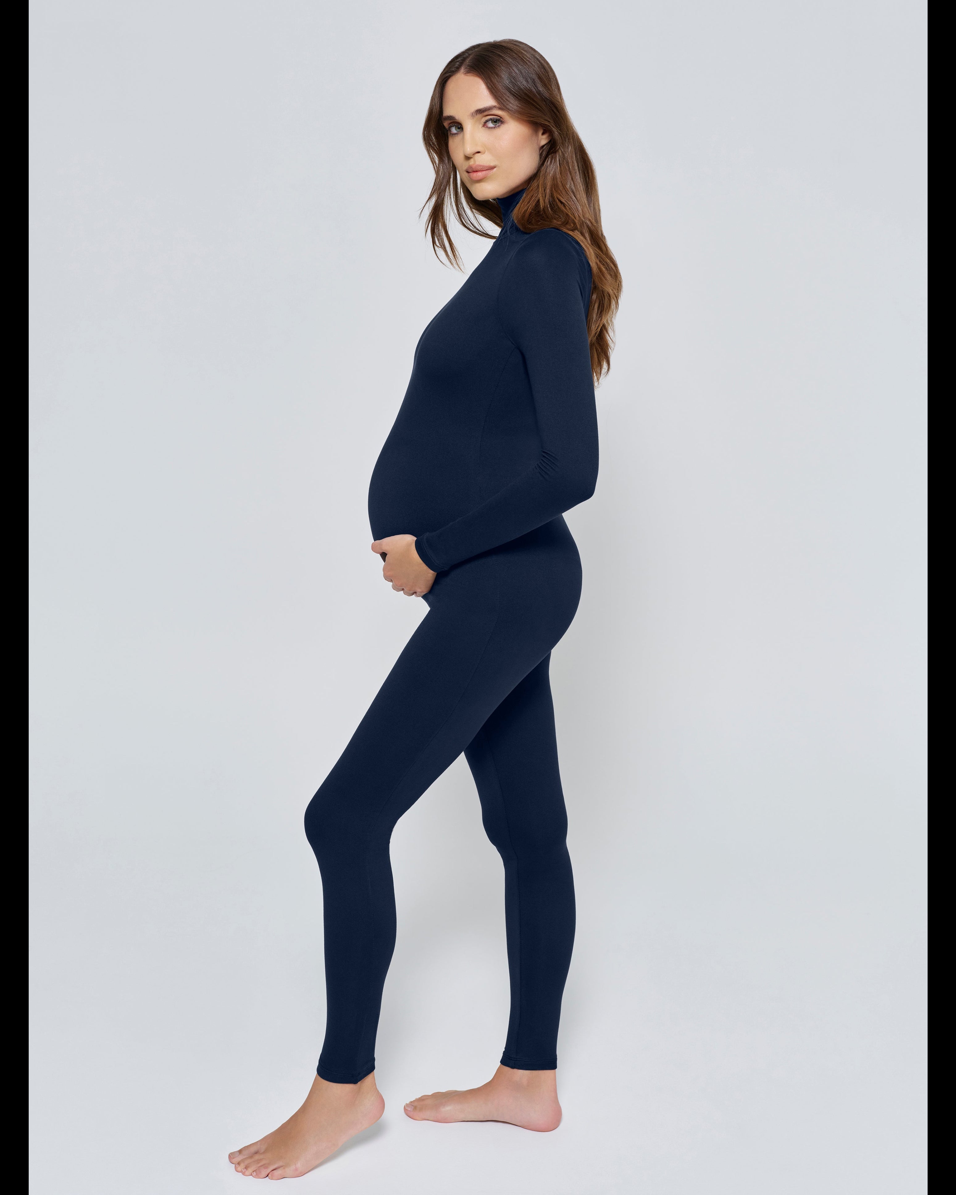 Pregnant woman wearing the Penelope Bumpsuit in Navy
