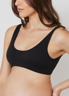Pregnant woman wearing the Bumpsuit Black maternity reversible comfy bra