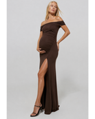 Pregnant woman wearing a chocolate coloured Bumspuit off the shoulder evening dress with a high leg split, set against a white background.