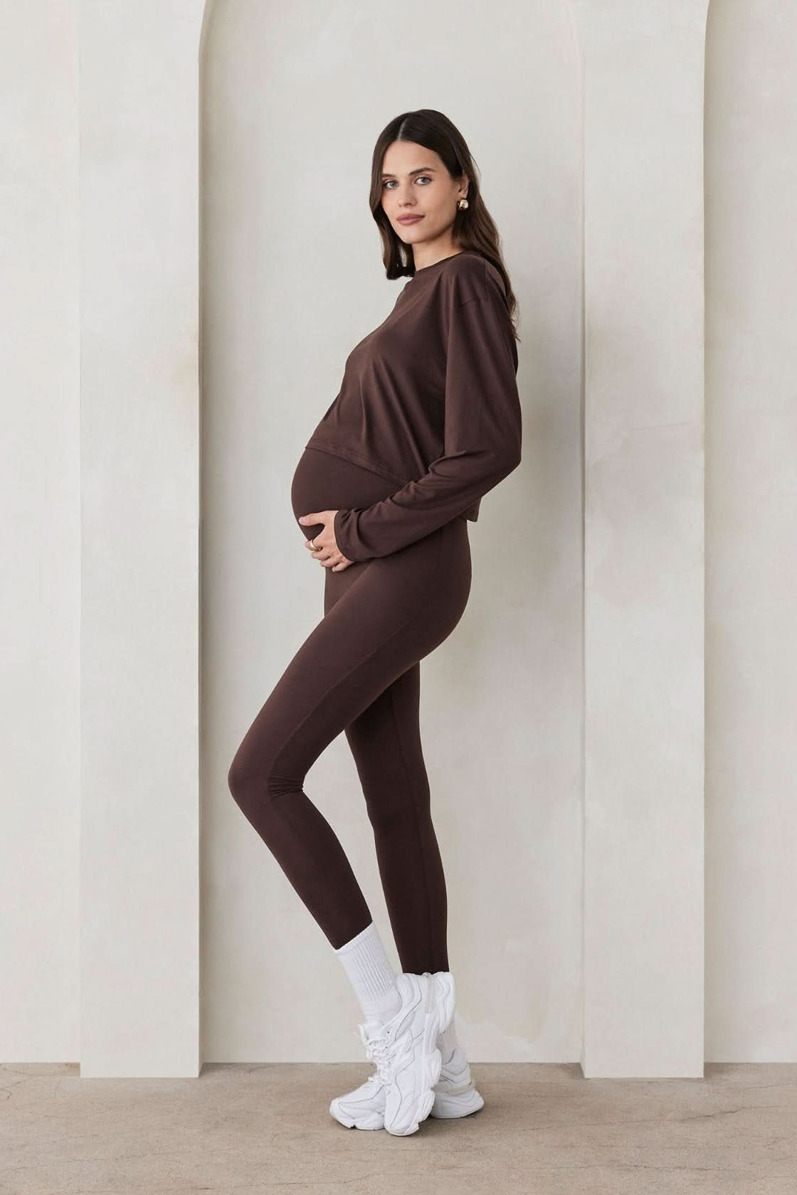 Pregnant woman wearing the Bumpsuit maternity the high rise full length legging in chocolate brown
