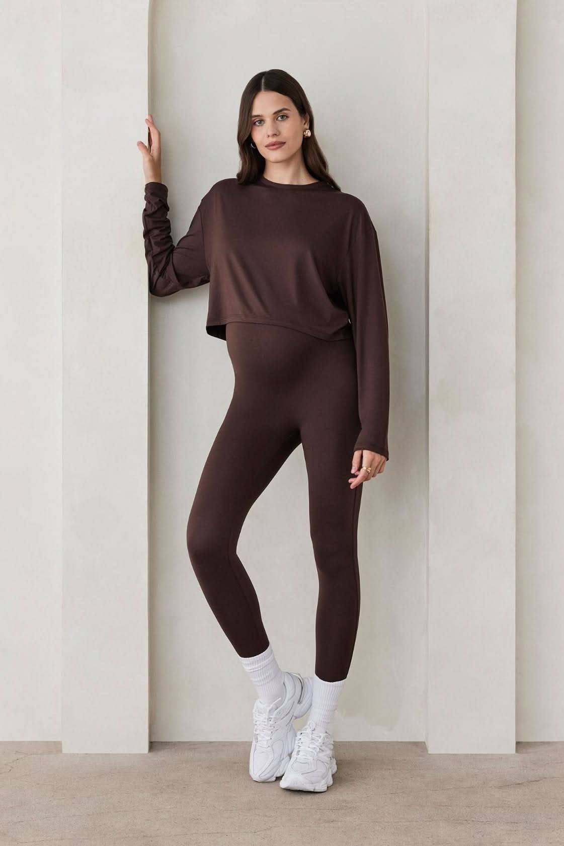 Pregnant woman wearing the Bumpsuit maternity the high rise full length legging in chocolate brown