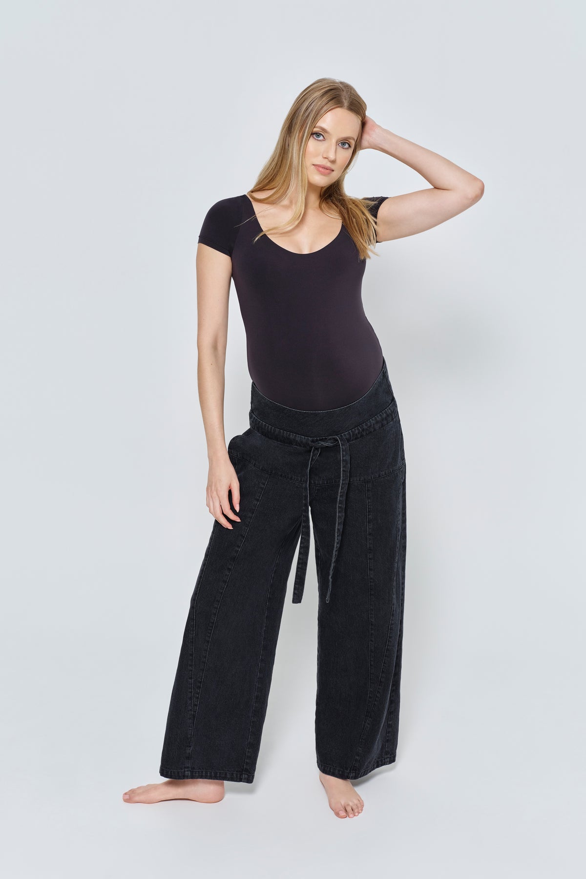 Pregnant woman wearing a black outfit on a white background