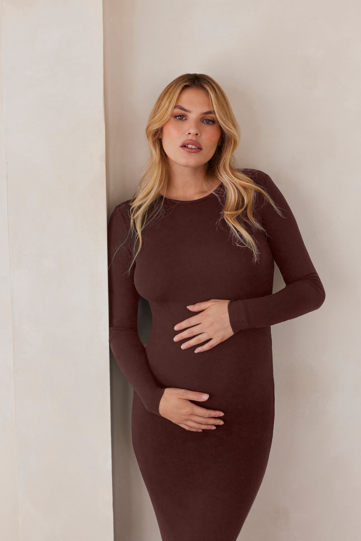 Front view of chocolate Soft Rib Maxi Long Sleeve Dress showcasing relaxed fit and ribbed fabric on a pregnant model indoors
