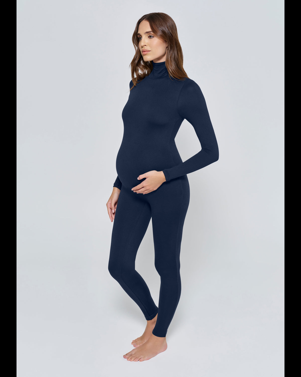 Pregnant woman wearing the Penelope Bumpsuit in Navy