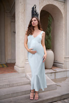Woman in a light blue dress standing on steps in an elegant outdoor setting