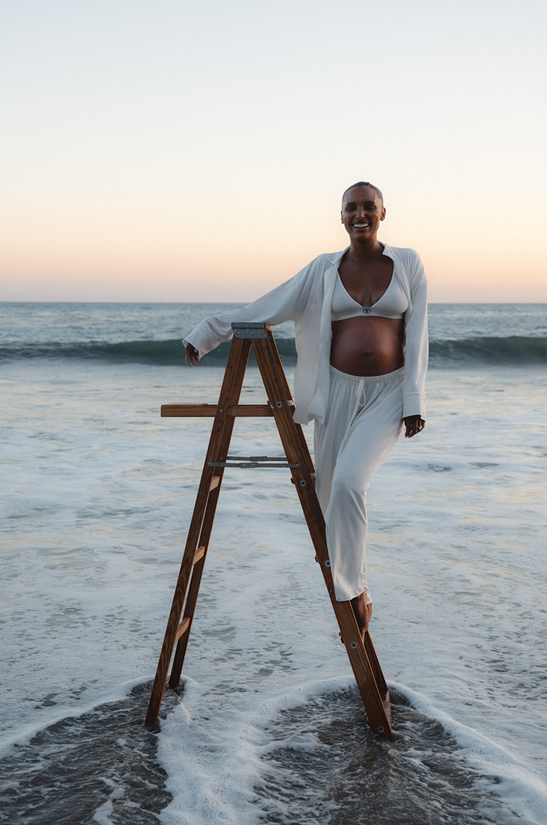 Jasmine Tookes standing on a ladder wearing Bumpsuits Luxe Bamboo Pj set