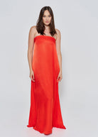 A woman wearing the Bumpsuit brushed satin strapless maxi maternity gown in red against a white background