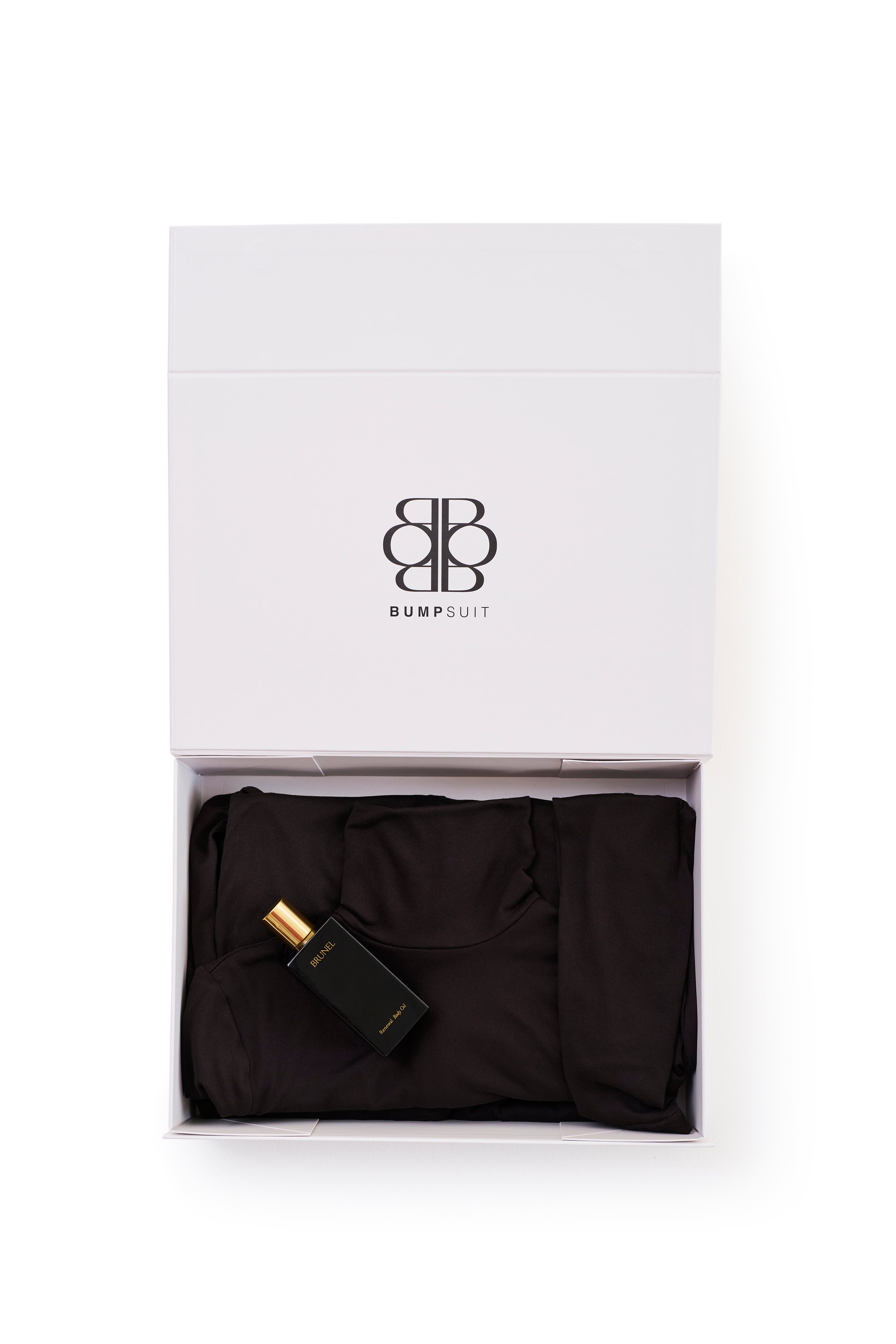 white box with the bumpsuit Monica dress in black and a body oil inside