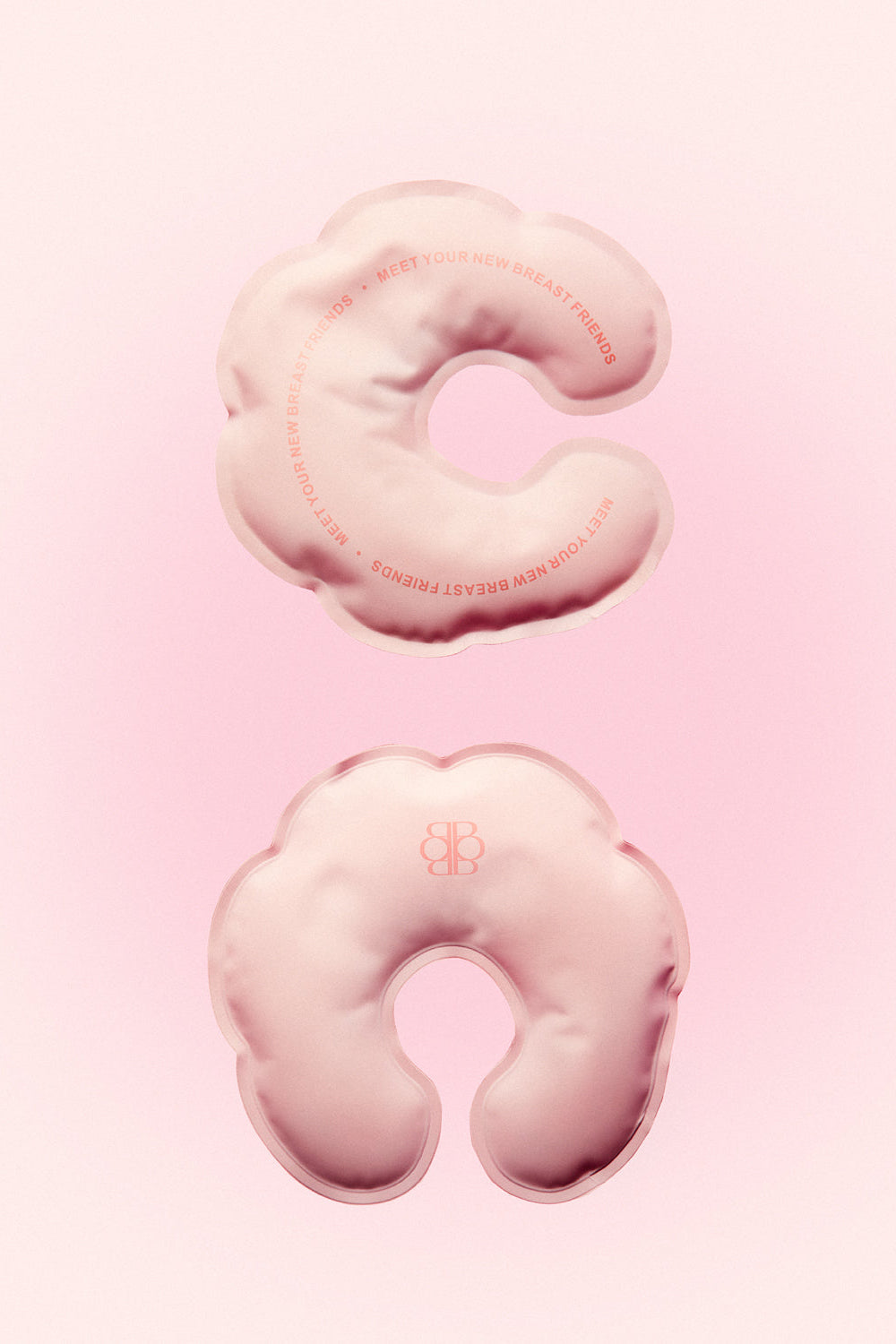 Front and back views of pink HOT-N-COLD BREASTIES breast therapy packs showing contoured reusable design on a pink background