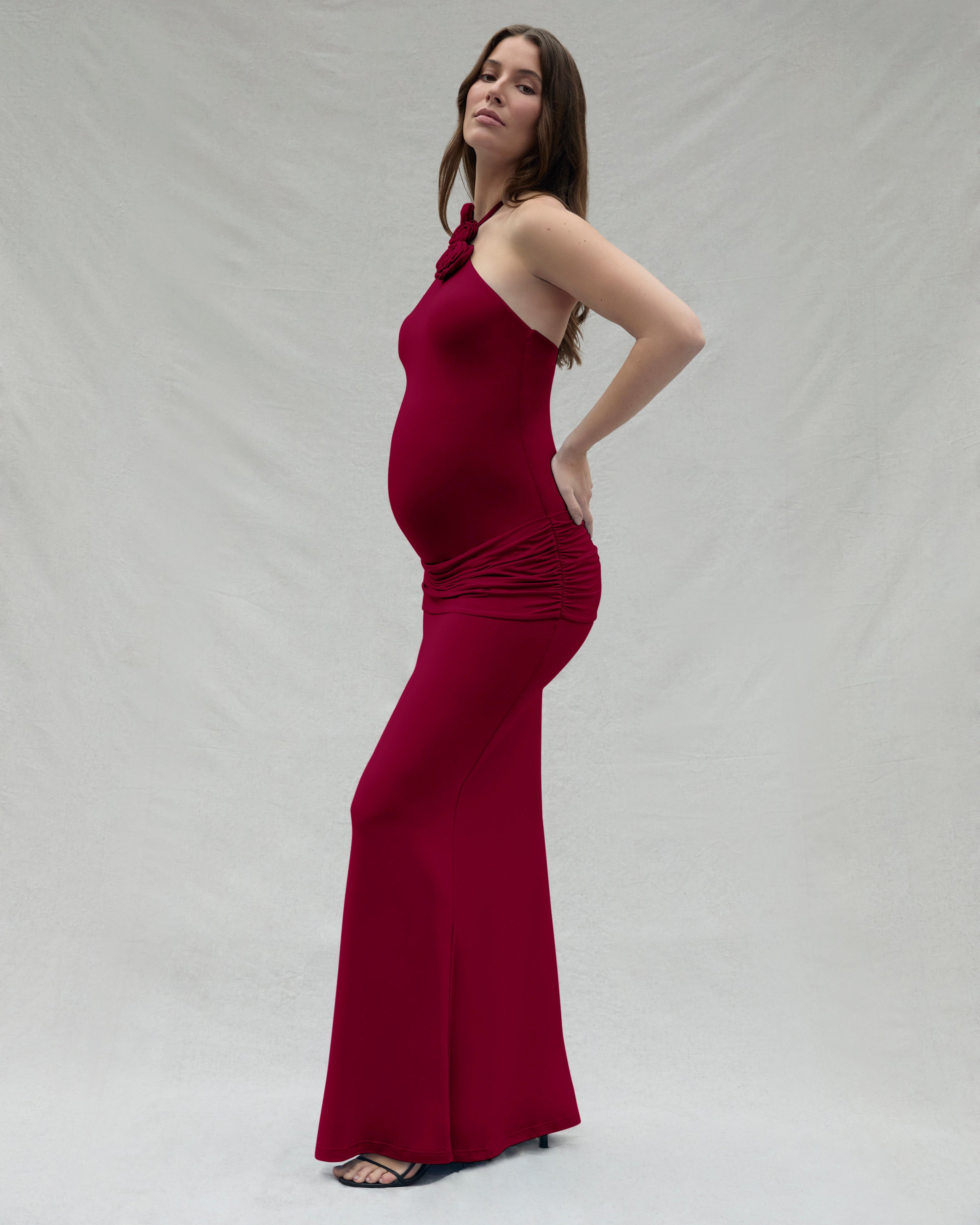 Woman wearing a burgundy dress against a plain background
