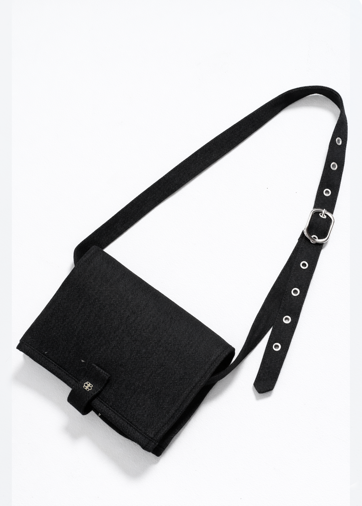 Black bumpsuit changing mat crossbody bag with a strap on a white background