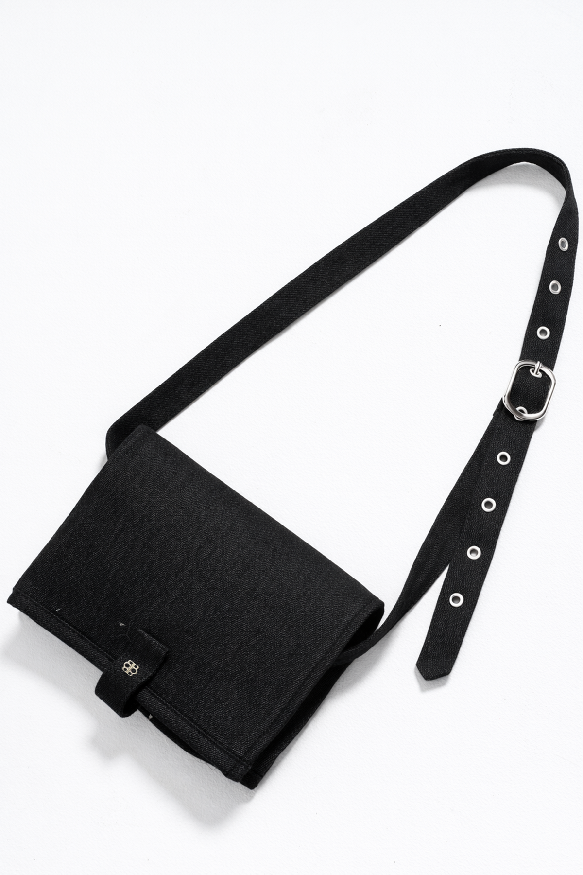 Black bumpsuit changing mat crossbody bag with a strap on a white background
