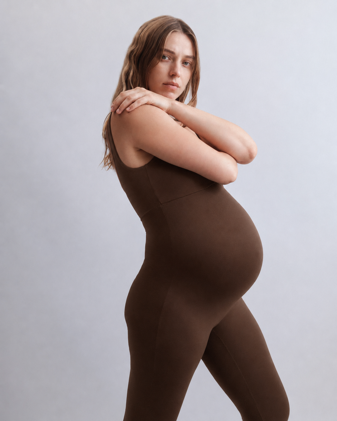 Woman wearing a Bumpsuit Chocolate brown bodysuit against a plain background