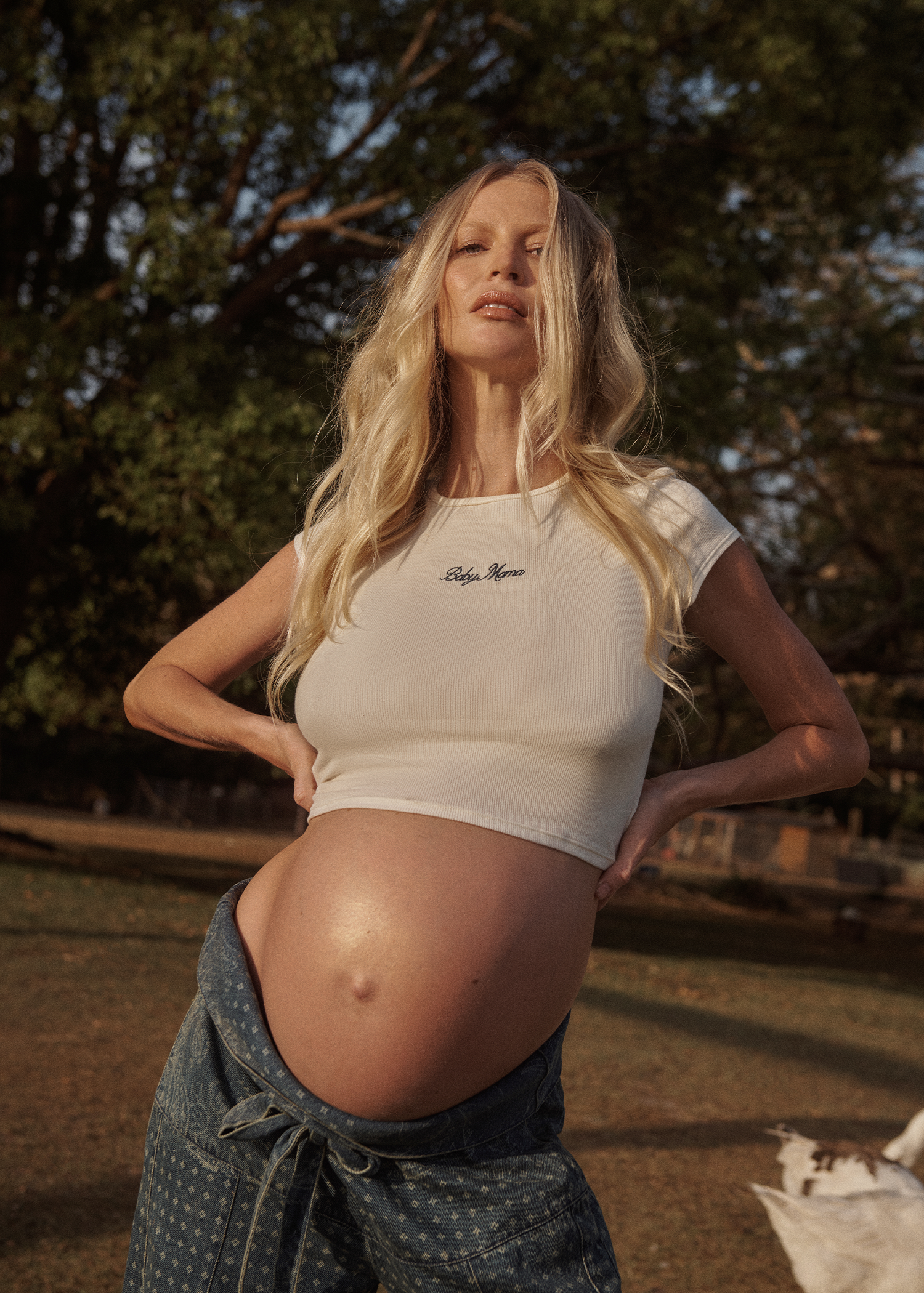 Pregnant woman wearing a white Bumpsuit baby mama tee