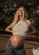 Pregnant woman wearing a white Bumpsuit baby mama tee